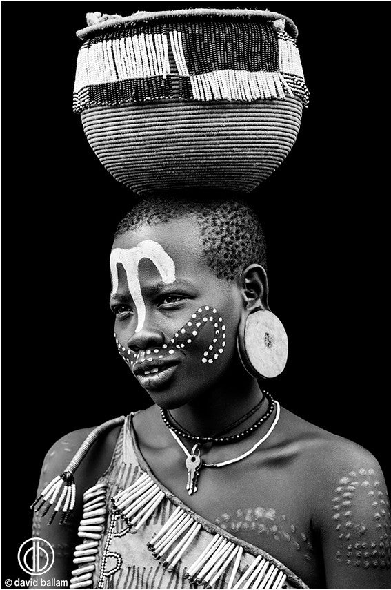 Ethiopian girl balancing basket on her head.