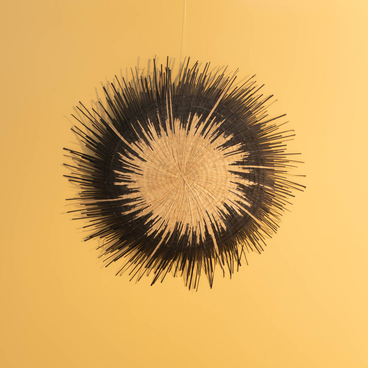 Sun circle black on a yellow wall