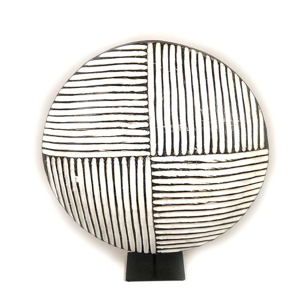 Round wooden Bamileke shield mounted with geometric pattern on a stand.