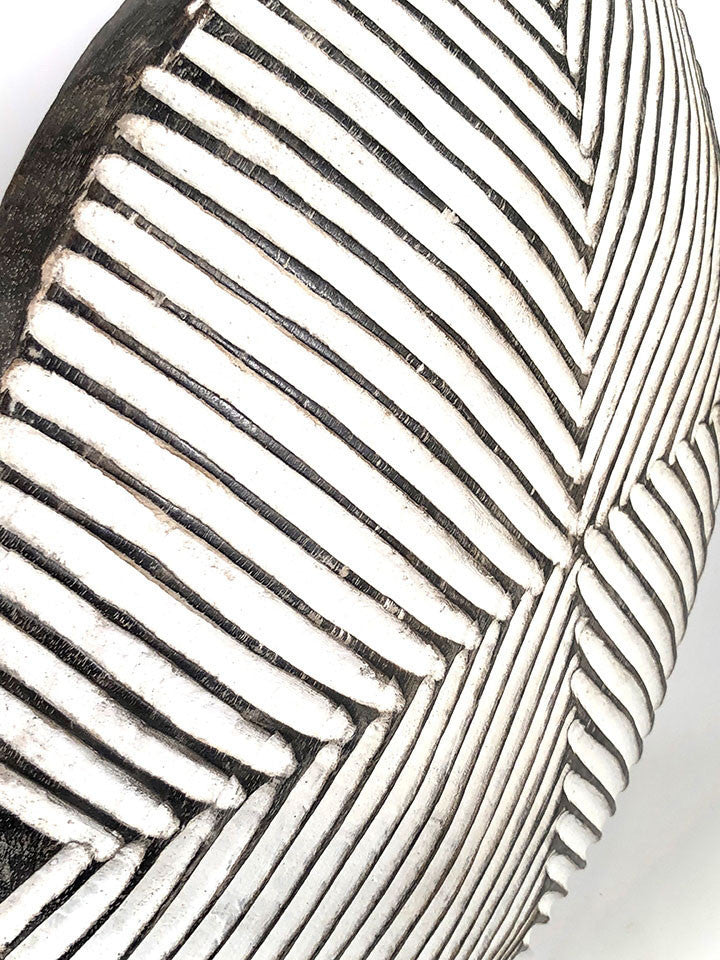 Round wooden Bamileke shield mounted with geometric pattern on a stand, detail.