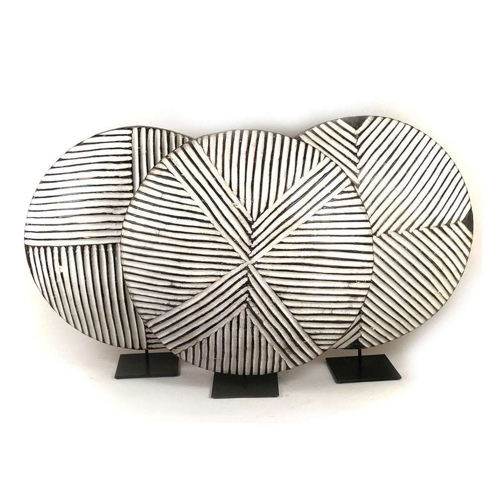 Round wooden Bamileke shield mounted with geometric pattern on a stand.