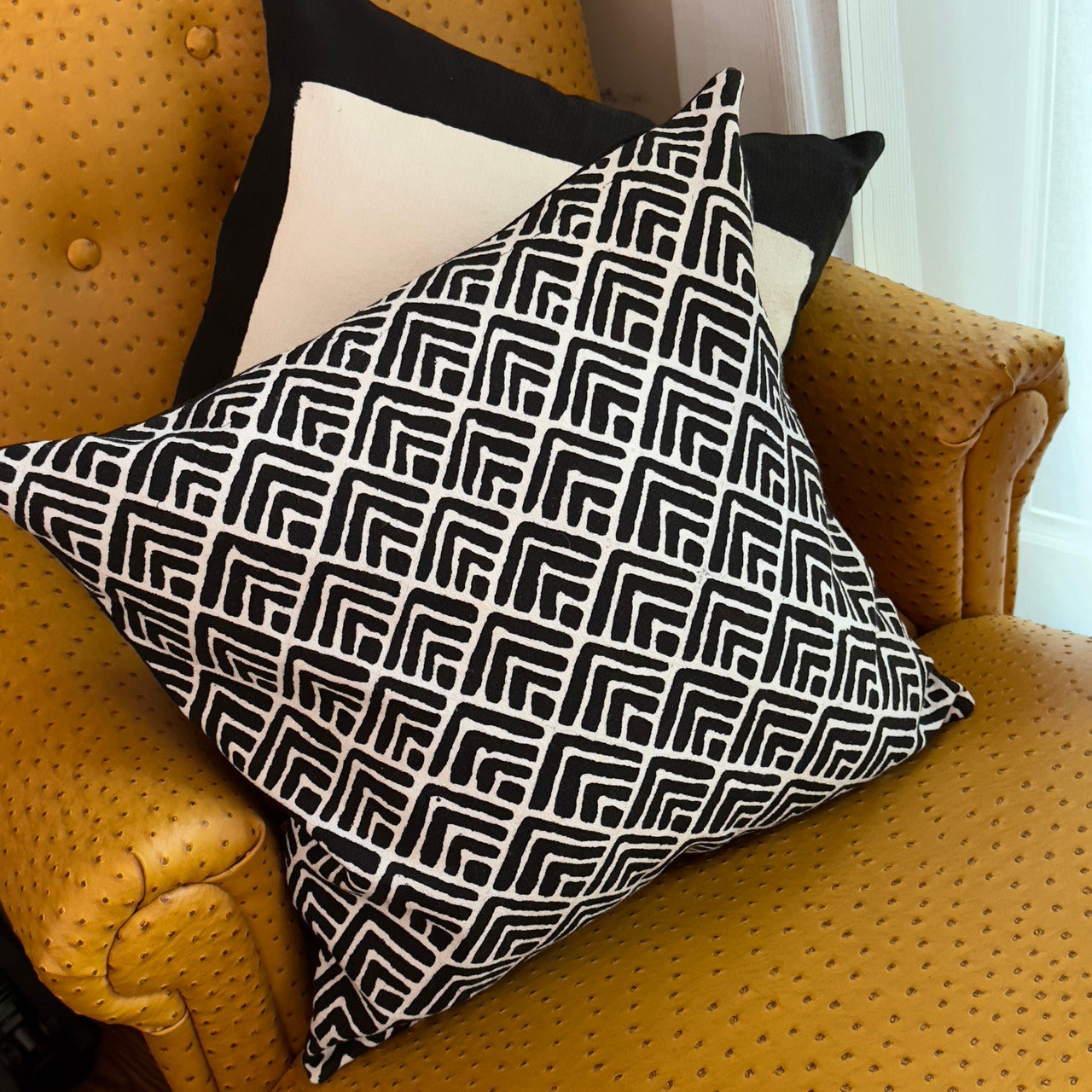 geometric shapes pillow on a sofa chair with squares pillow