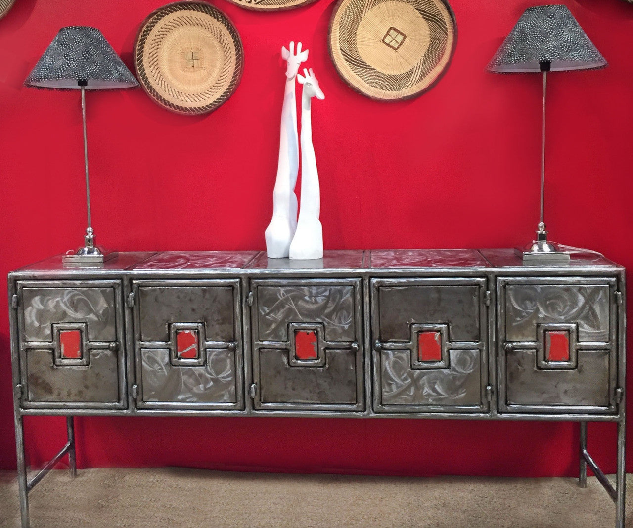 Recycled metal credenza by a red wall