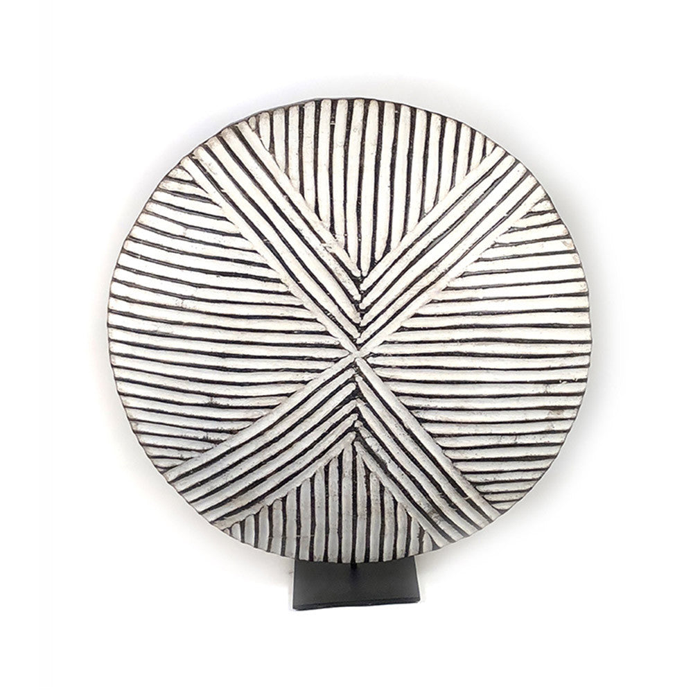 Round wooden Bamileke shield mounted with geometric pattern on a stand.