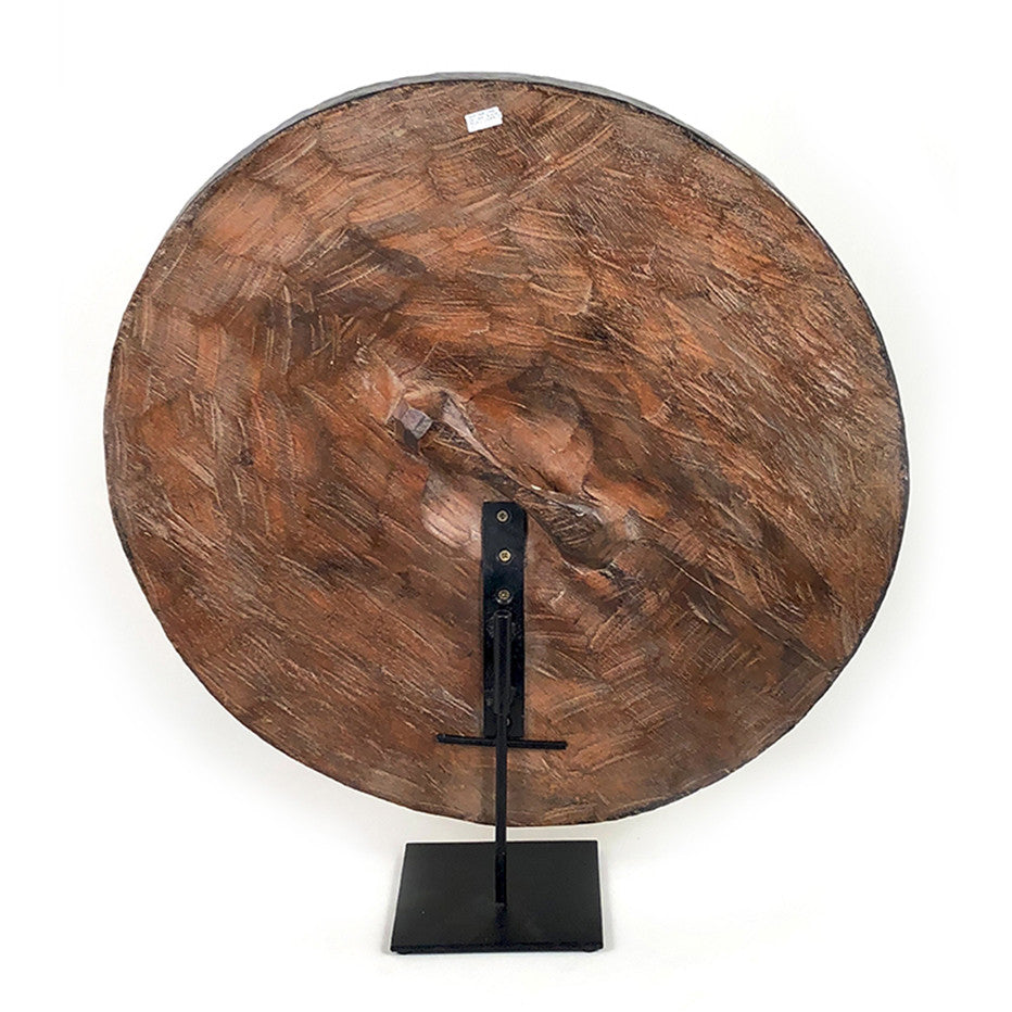 Round wooden Bamileke shield mounted with geometric pattern on a stand, back side.