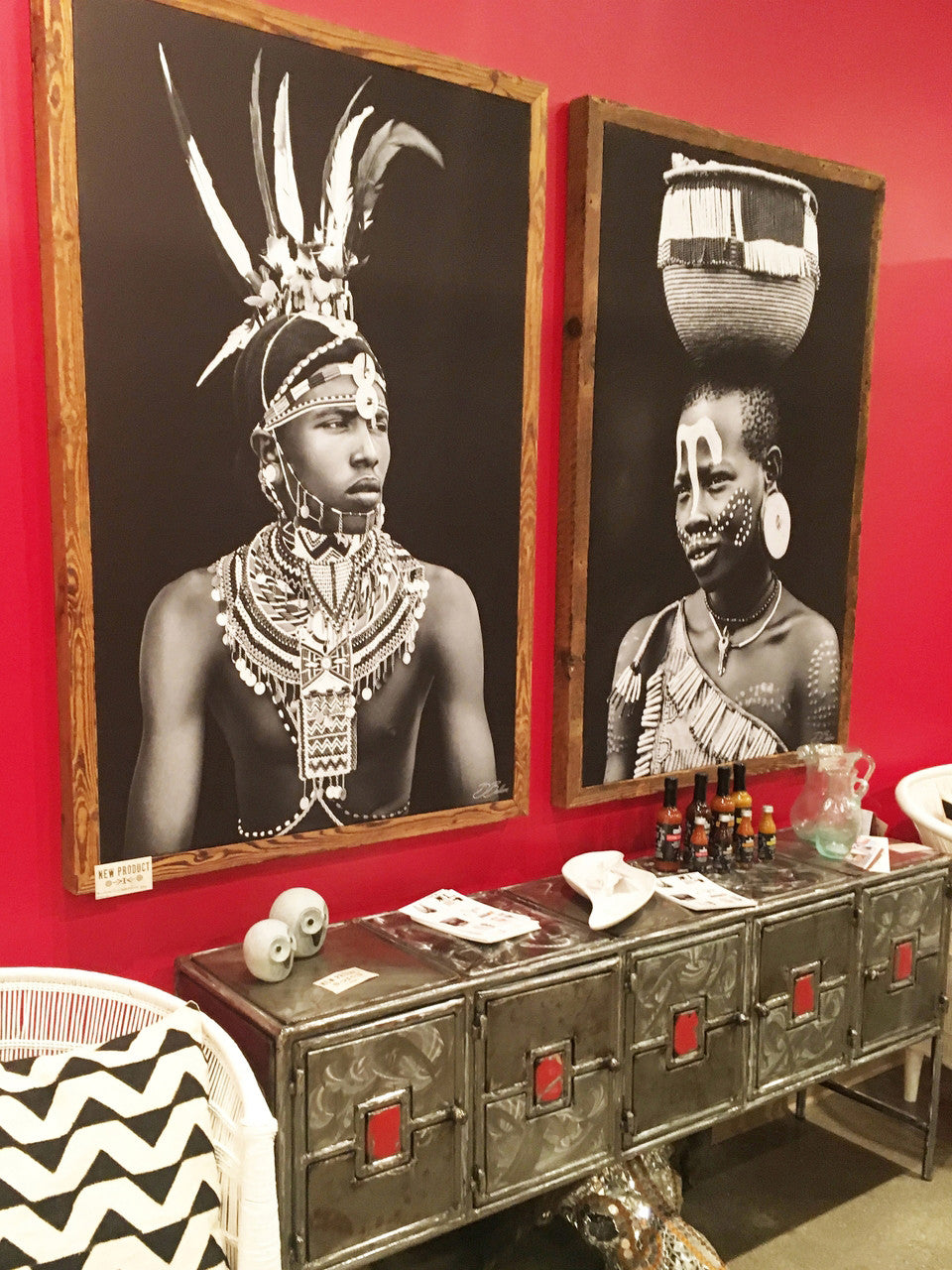Ethiopian girl and Kenyan man photographs on canvas on a red wall.