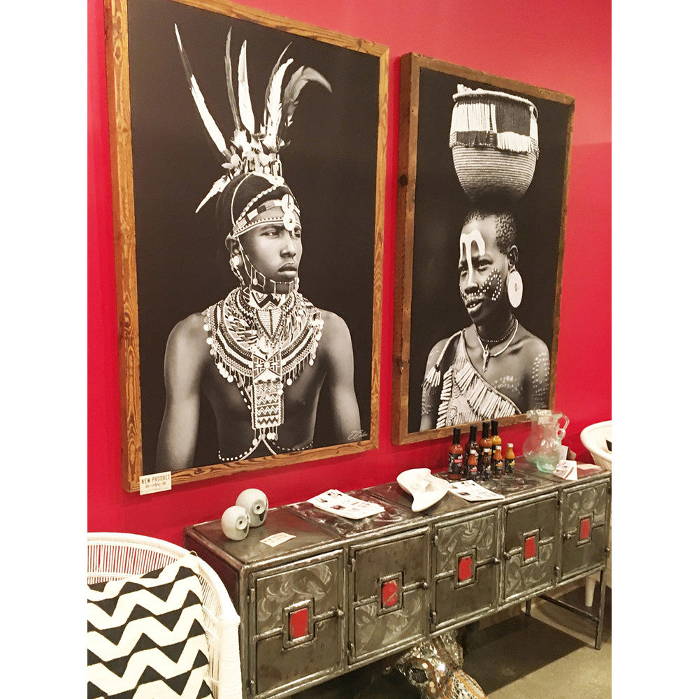 Kenyan man and Ethiopian woman photographs hanging side by side on a red wall hallway.